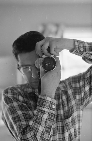 Edwin Stein, <i>Wisconsin State Journal</i> photographer, takes a photograph of himself in a mirror.