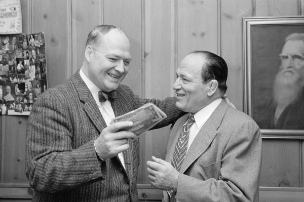 <i>Wisconsin State Journal</i> sports editor Henry J. McCormick (left) accepts $150 cash from wrestling promoter Jimmy Demetral for the paper's Empty Stocking Fund.