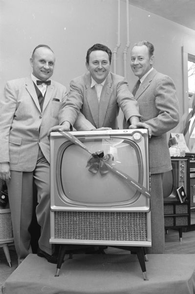 Madison Lions Club members Bernard C. Reese (left) and Deane Johnson (right) present a Motorola television set to Edward Karpowiez, recreational therapy director at Mendota State Hospital. It is the third presented to the hospital this year from profits made with a gumball concession.