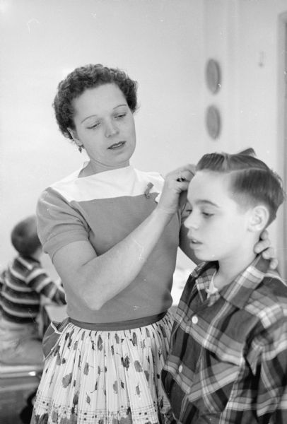 Meredeth Niemczyk checks the part in the hair of her 11-year-old son, Tommy, before leaving for her school crossing guard job at the corner of Jenifer and Brearly streets.