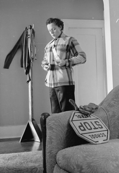 Crossing guard Meredeth Niemczyk dresses for the weather in a plaid wool jacket and heavy pants. In the foreground on the couch is her portable hand held stop sign.
