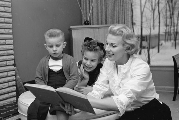 Madison television personality Beverly Stark reading to her two children, Randy and Shelley, at home where she does a good share of her professional work.