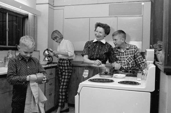 Cherokee Junior High seventh grade teacher, Paula Suomi, at home in the kitchen with her three children, Eric, Lois, and Stephen.