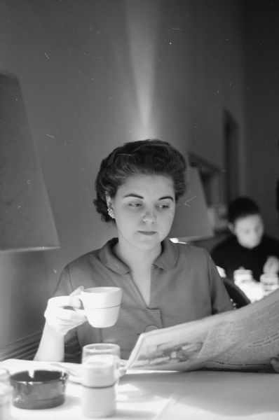 Mrs. Gerald (Christina) Lorge, wife of Sen. Gerald Lorge (R-Bear Creek), is shown reading and sipping coffee while waiting for her husband, who is in a legislative session.