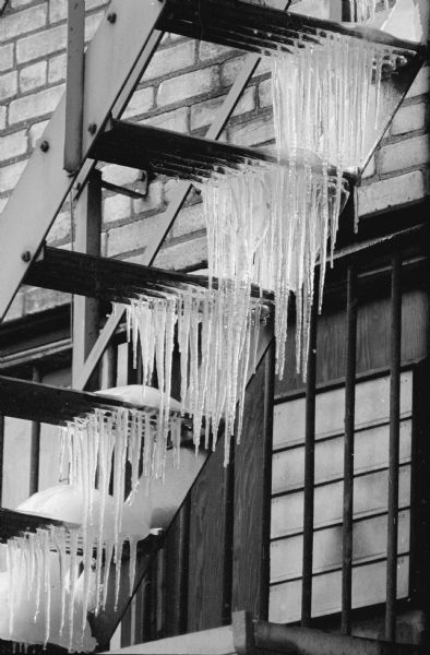 Icicles hanging from the steps of a fire escape.