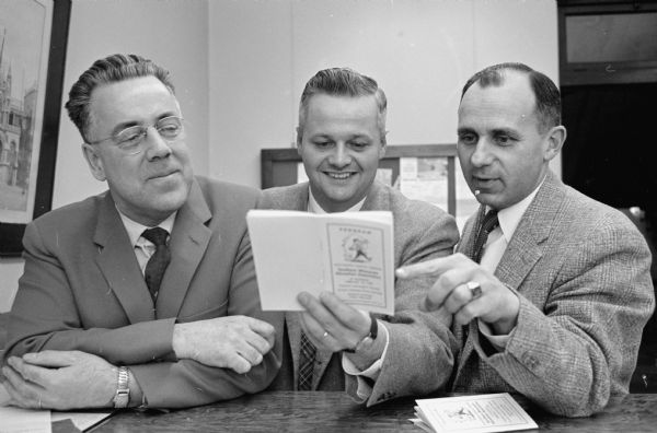 Three men checking the schedule for the meeting of the Southern Wisconsin Education Association. Left to right: William Marsh, Madison, secretary; Frederick C. Reineking, Wisconsin Dells, president; and Edmond Schwan, Monona Village, incoming president.