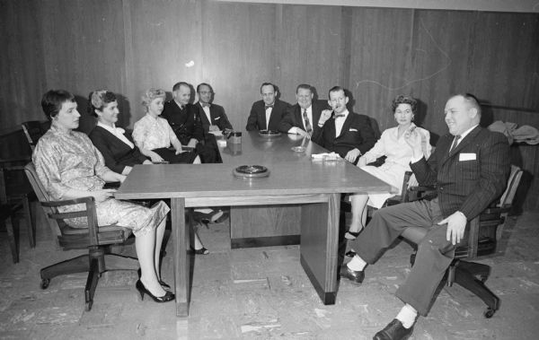 The Madison Police and Fire Commission explores a traffic accident involving Police Chief Bruce Weatherly and witnesses' claims that he was under the influence of liquor the evening of the accident.<br>Witnesses wait to testify before the commission. Shown (L-R) are Mrs. Donald Millard, wife of a Madison tavern-keeper; Mrs. Ganet Litchen, 2933 Monroe Street, Hoffman House Restaurant customer on the evening of January 8, 1959; Mrs. Lyall Leverentz, hat check girl at the Hoffman House; Police Sgt. Arnold Braeger; Cyril J. (Cy) Hoffman, co-owner of the Hoffman House; Jack Flanagan, 1042 Spaight Street, Hoffman House bar manager; Howard Shawkey, 141 N. Hancock Street, Hoffman House bartender; Jack Tremblay, Hoffman House bartender; Mrs Bruce (Inez) Weatherly; and Don Millard, E. Wilson Street tavern operator.</br>