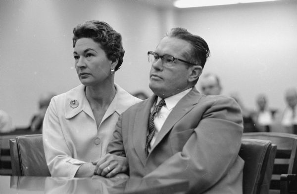 The Madison Police and Fire Commission explores a traffic accident involving Police Chief Bruce Weatherly and witnesses' claims that he was under the influence of liquor the evening of the accident.<br>Mrs. Bruce (Inez) Weatherly and Police Chief Weatherly listen as the commission announces that they had found the police chief guilty of the four misconduct charges against him.</br>