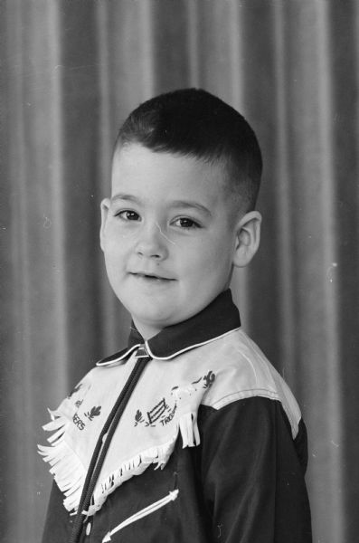 Portrait of Dickie Manion, one of seven kindergarten members of the Edgewood campus school whose photograph is featured in a newspaper article about the "little people" of Ireland such as leprechauns and banshees.  Dickie is wearing a shirt depicting Roy Rogers and Trigger, a popular shirt of the time. 