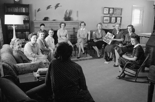 When Joan Carlton of Oakpark, Illinois married Reed Forbush of Appleton, Wisconsin she was skeptical of life as a minister's wife. Now, as a series of photographs shows, she enjoys her life as the wife of the pastor of Middleton Community church. Joan serves as secretary of the Mission Study group meeting in the home of Mrs. George Dehnert.