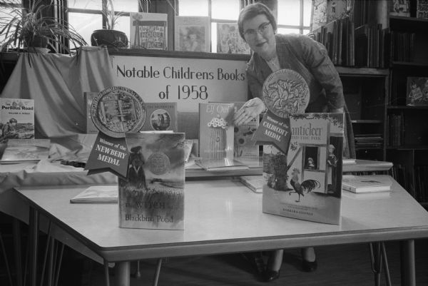 An exhibit of 34 children's books at the Madison Public Library. They were chosen as the best books published for children in 1958. Pictured is Faith Hektoen, head of the children's section of the Madison Library.