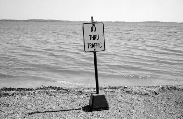 The Madison Police Department erects a sign at the Law Park shoreline of Lake Monona to discourage boaters from launching their boats due to lake debris left from the winter ice thaw. The sign reads: "No Thru Traffic."