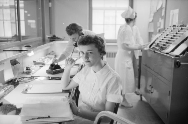 Agnes Moore, a psychiatric nurse-in-training, is shown at University Hospital studying the medical report of a patient.