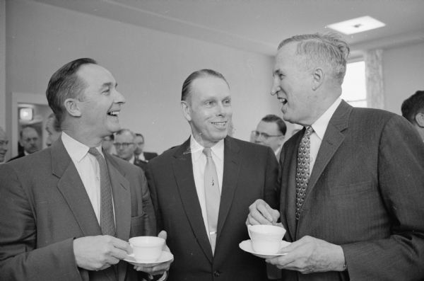 Three men who figured prominently in the dedication of the Mathematics Research Center are shown talking before the ceremonies. Left to right:  Wilbur Renk, president of the Board of Regents of the UW; Conrad A. Elvehjem, president of the University; and Thomas Brittingham, Jr., president of the Wisconsin Alumni Research Foundation.