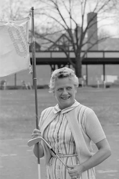 Mrs. Lester Lee, 1 Chippewa Court, President of the Nakoma Country Club women's organization, standing on the 18th green, preparing for the upcoming golf season.