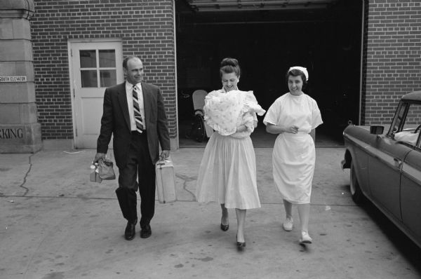 Mr. & Mrs. (Alice) Richard Welch, 4410 Boulder Terrace, leave St. Mary's Hospital with their new baby girl, Andrea, escorted by student nurse Miss Nancy McManamy, Reedsburg. Andrea is the first girl born in the Welch family in two generations.