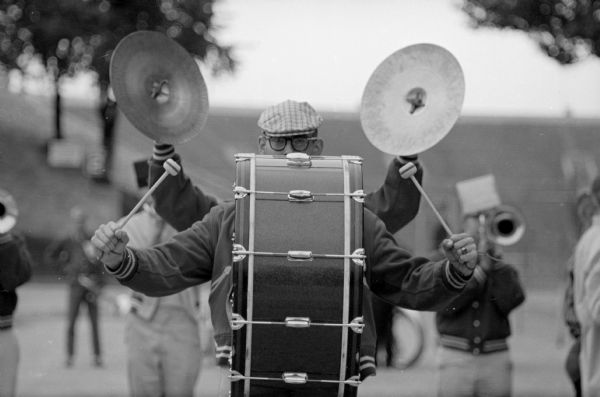 Members of the UW band practice prior to playing at the UW football game versus Minnesota. The four-armed band member is really drummer Charles Sommers, graduated student from Pardeeville, and cymbal player Dennis Helsabeck, 241 Langdon Street, following behind the drummer.