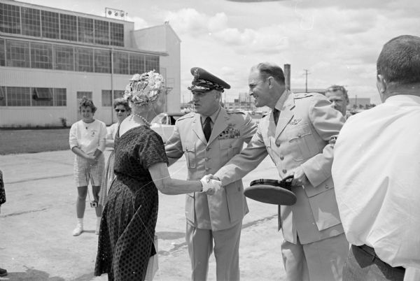 General Nathan F. Twining, Chairman of the Joint Chiefs of Staff (1957-1960), arrives at Truax Field on his way to visit his hometown of Monroe on the 4th of July holiday. General Twining is shown greeting his sister, Mrs. Howard Chadwick from Monroe.