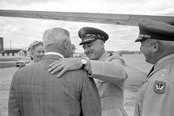 General Nathan F. Twining, Chairman of the Joint Chiefs of Staff (1957-1960), arrives at Truax Field on his way to visit his hometown of Monroe on the 4th of July holiday. General Twining is shown greeting George Van Wagenen, formally of Monroe and now living in Minneapolis. The two men grew up together in the same Monroe neighborhood.