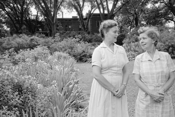 Dr. Jane Hanks, Bennington, Vt. and Sybil Hanks are shown standing in the garden at the Lucien M. and Mary Esther "Mollie" Vilas Hanks house at 525 Wisconsin Avenue at Langdon Street. The event was the last open house fundraiser for Attic Angels before the property was to be sold.
