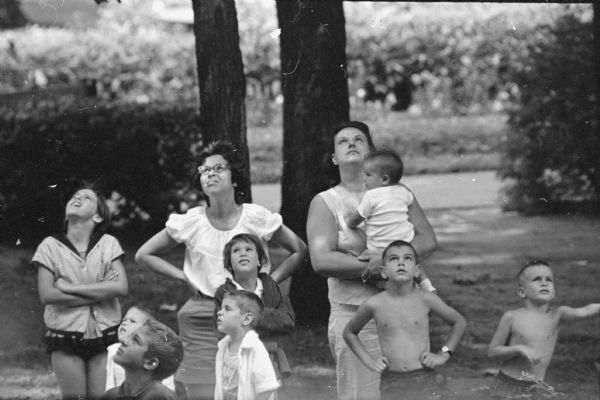 Thirty-eight Rhesus monkeys escaped from the basement of the Vilas zoo monkey house on August 4, 1960. Sixteen were captured right away but it took until December 5 to capture the rest. Women and children are looking up into the treetops.