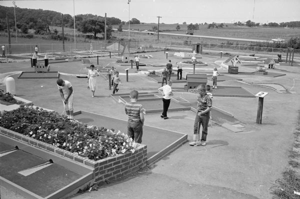 Golfers playing the miniature golf course at George Vitense's Golfland; a combination of a miniature course, a par-three 18-hole layout, a driving range and professional instructors.