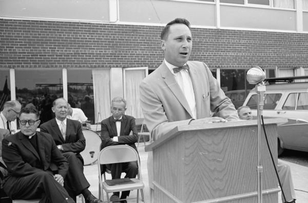 More than 300 people attend the annual Labor Day program sponsored by the Madison Federation of Labor at the Labor Temple, 1602 S. Park Street. Al Brickson, president of the federation, is shown addressing the crowd. Behind the rostrum at Brickson's right is George Herb, chairman of the Dane County Board.