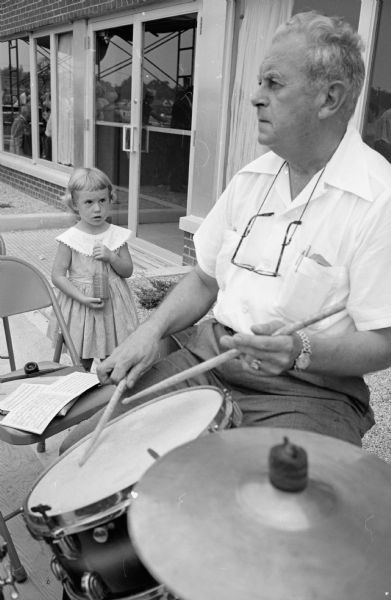 More than 300 people attend the annual Labor Day program sponsored by the Madison Federation of Labor at the Labor Temple, 1602 S. Park Street. Drummer Harold Swearingen, 36 S. Marquette Street, performs at the festival with the Elmer Zingler Band. Terri Ann Milton (3), daughter of Mr. and Mrs. Vincent A. Milton, 4401 Somerset Lane, listens as the band performs.