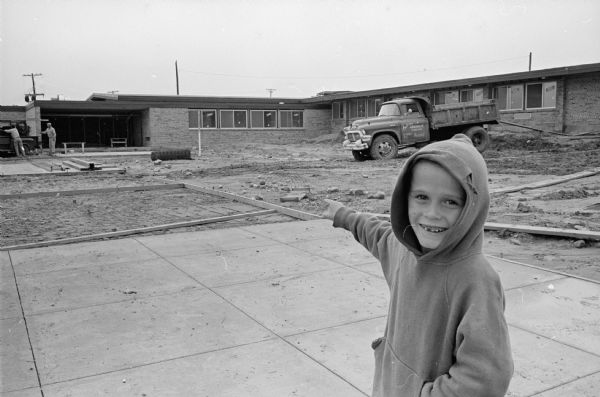 Tim Garske (age 6), 1332 Monica Lane, points to the new Samuel Gompers Elementary School under construction at 1502 Wyoming Way on the northeast side of Madison.