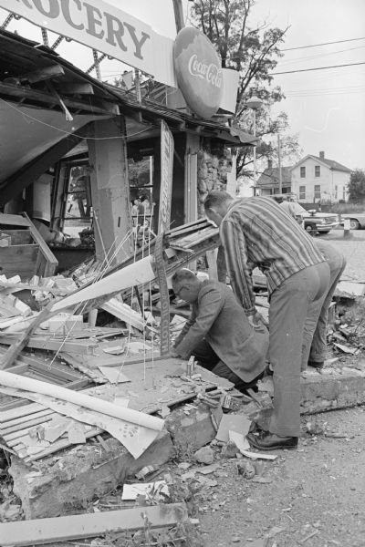 A gas explosion demolishes the Kellor's Store and Garage near Oregon. Under-sheriff Jack Leslie (L) and Deputy Robert Johnson are shown attempting to find the possible leak from underground gasoline storage tanks which was believed to have caused the blast.