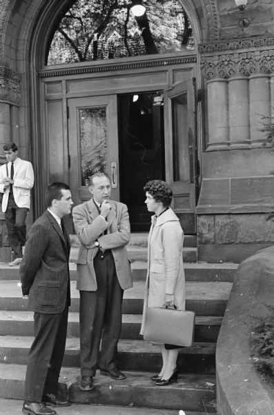 Carol Baumann discusses one of her three jobs at the University of Wisconsin with her boss Prof. Carlisle P. Runge of the Law School, and Joel Smith, left, a research assistant on the same project.