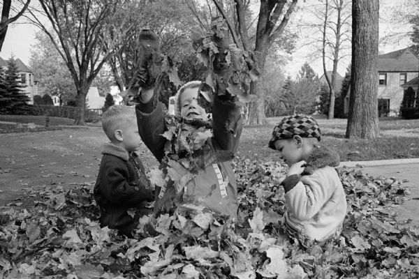Five year-old Paula Scharch, and her brother Stanley, age three, tossing leaves.