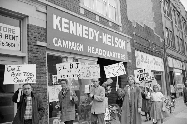 University Republican students picketing the Kennedy-Nelson campaign headquarters at 610 University Avenue, carrying signs asking why the Democratic campaign here is silent on the Democratic vice-presidential candidate, Lyndon B. Johnson. The name of the headquarters refers to John F. Kennedy and Wisconsin Governor Gaylord Nelson.