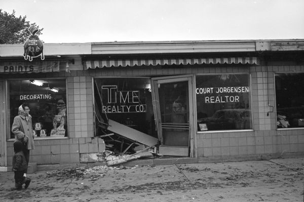 The smashed-in storefront of the Time Realty Company building at 2434 University Avenue as a result of a car backing up with a stuck accelerator.