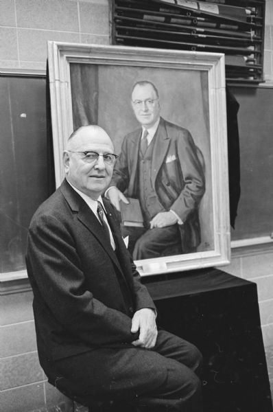 Dr. Robin Buerki, physician, teacher, organizer, administrator and distinguished alumnus poses before his portrait that was unveiled and presented to the University. Dr. Robin Buerki, of Detroit, was the first superintendent of University hospitals from 1923 - 1942.