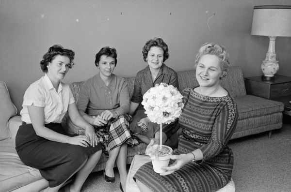 Four members of the Madison Pharmacists Women's club admire a rosette tree hand-made for a table decoration at the club's annual dinner dance at the Nakoma Country club. The trees will be sold to raise money for a scholarship for a woman pharmacy student at the University of Wisconsin. The club members are, left to right, Barbara Hammel, Cathryn Stieb, Genevieve Busse, and Doris Frank (club president).