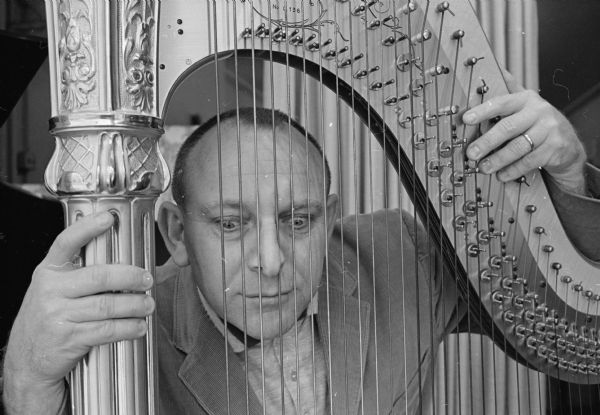 Ben Rhodes, manager of Forbes-Meagher Music Company's instrument department, poses with the harp on display at the store.
