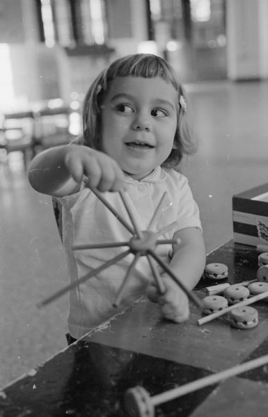 Kathy Conto (3) entertains herself at the Salvation Army all day nursery school, 121 West Wilson Street. Anne Shea serves as the head teacher and is assisted by Mrs. Belva White. The school can accommodate up to twenty students ages 2 1/2 to 5 years old.