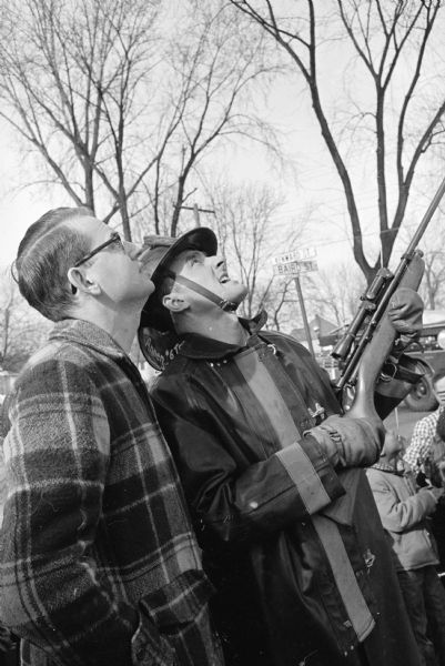 Dan Watson, left, director of the Vilas Park Zoo, and fireman Don Annen  attempting to capture two rhesus monkeys in the tree tops. Annen is holding a tranquilizer gun. The monkeys escaped from the zoo on August 4th, 1960, along with 36 other monkeys. Sixteen were soon caught but it wasn't until December 5th that these last two were captured.