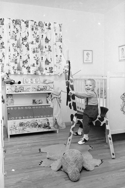 Mike Elliott is shown riding his favorite wooden giraffe in his room in the "dream House" built from plans in the <i>Wisconsin State Journal</i> by his parents Mr. and Mrs. Harold F. (Schim) Elliott.