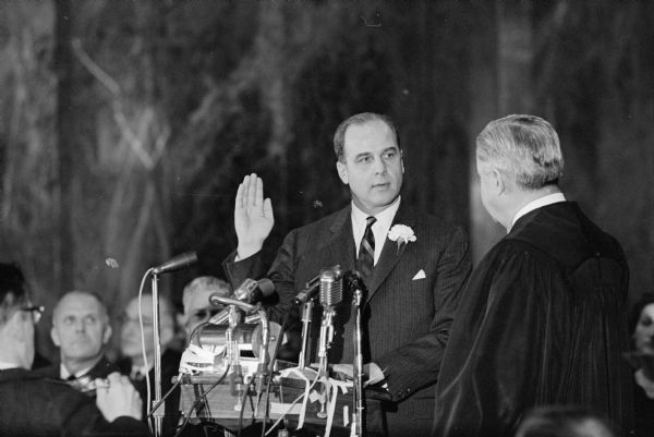 Supreme Court Chief Justice John E. Martin administers the oath of office to newly elected Governor Gaylord A. Nelson during the inaugural ceremonies in the State Capitol.
