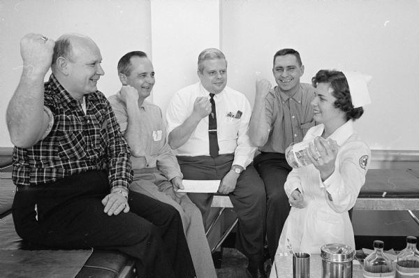 Red Cross Nurse Janis Clothier is shown at right holding a container. With her are four building inspectors during a Red Cross blood drive for government workers at the City-County building. The men are, left to right: Clifford D. Kenison, Donald M. Jones, Bradley D. Eames and Sherril E. Walker.  