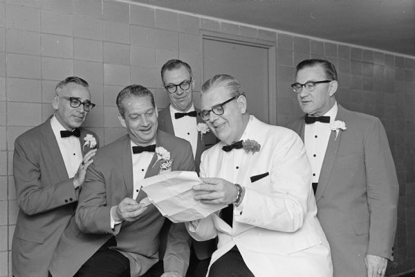 Members of the conference committee checking details for the 11th annual Madison Sales Conference. Left to right are: Harry McGuire, Wolff-Kubly and Hirsig; E. A. Faust, Wisconsin Telephone Company; James Lichty, University of Wisconsin School of Commerce; John A. Colby, CUNA Mutual Insurance Society, conference chairman; and F. F. Malcolmson, CUNA.