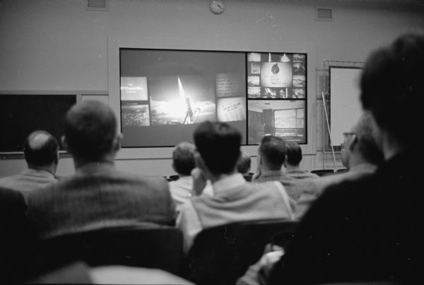 Telemation, a revolutionary audio-visual method of presenting instructional material was premiered at the University of Wisconsin education building auditorium. The view from the lecture hall shows three separate screens illustrating the words of the lecturer.