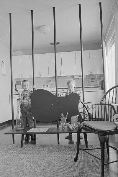 One of a series of photographs depicting ways U.W. graduate students have made their small apartments more attractive and livable. Shown is David, left, and his brother Stephen standing behind a room divider made by their parents, Mr. and Mrs. Dan Anderson. They also made many of their pieces of furniture.