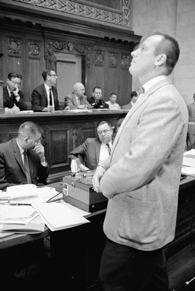 Public hearing on the proposed abolition of the House Un-American Activities committee at the Wisconsin State Capitol. Emil Muelver, Milwaukee, listens to a tape recording during the hearing.