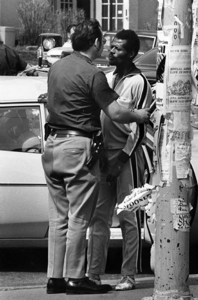A police officer apprehending a shoplifter on the sidewalk along State Street.