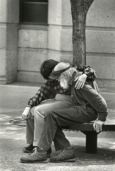 Elderly man comforted while sitting on a bench at Library Mall.