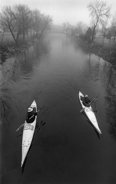 Elevated view from the Division Street brdige of two kayaks paddling down the Yahara River.