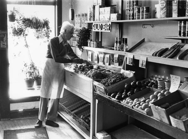 A grocer sorting through produce in Di Salvo's Italian grocery store. 